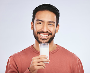 Image showing Man with milk, drink and health with nutrition, calcium and vitamins with vanilla shake isolated on studio background. Dairy product in glass, beverage and male person smile, healthy and portrait