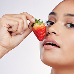 Image showing Face, lips and strawberry portrait of a woman in studio for beauty glow, dermatology or natural cosmetics. Female person with fruit in hand for detox, healthy diet and skincare on a white background