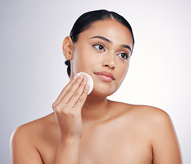 Image showing Face, cleaning and cotton on skin of a woman in studio for natural beauty, dermatology or cosmetics. Female person with skincare wipe in hand for glow, healthy and clean facial on a white background