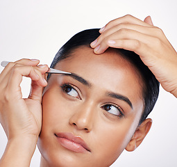 Image showing Face, woman and plucking eyebrows with tweezers in studio for self care and hair removal. Headshot of natural model person with beauty tools in hand for cleaning and grooming on a white background