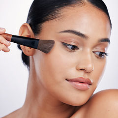 Image showing Makeup, face brush and beauty of a woman in studio for skin glow, foundation or cosmetics. Headshot of a female model with cosmetic tools in hand for facial powder and shine on a white background