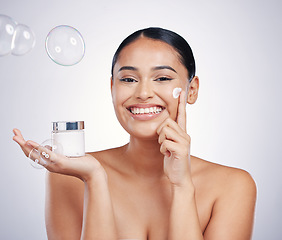 Image showing Beauty cream, face and skin of woman in studio for glow, dermatology and cosmetics. Portrait of happy female model with product container in hand with bubbles, skincare and health on white background