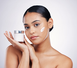 Image showing Face, beauty and skin cream for woman in studio for glow, dermatology and cosmetics. Portrait of female model with product container in hand for skincare, self care and wellness on a white background