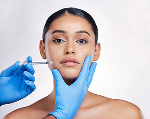 Image showing Woman, studio and needle in portrait, surgery or cosmetics for skin, facial or collagen by white background. Girl cosmetic surgeon and filler on face, syringe or hands for beauty, skincare or change