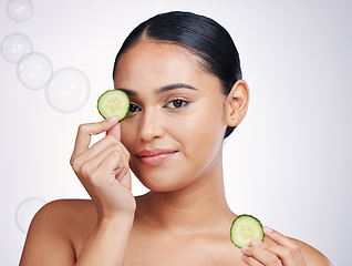 Image showing Cucumber, face and beauty of a woman in studio for skin glow, dermatology and cosmetics. Portrait of model person with a vegetable in hand for natural facial, health or wellness on a white background