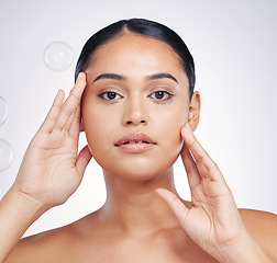 Image showing Beauty, natural and woman with hands on face in studio for glow, skin dermatology or cosmetic. Portrait of aesthetic model person with bubbles for self care, facial or skincare on a white background