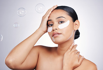 Image showing Eye mask, face and a woman in studio for beauty glow, dermatology or natural cosmetics. Portrait of aesthetic model person with a skincare patch and bubbles for facial self care on a white background