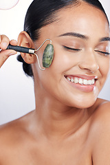 Image showing Face roller, skin and a woman in studio for beauty glow, dermatology or natural cosmetics. Happy female model with self care tools for facial massage and skincare results on a white background