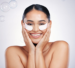 Image showing Face, portrait of woman with eye patches and against a studio background with happy smile. Cosmetics or beauty makeup, skincare wellness and young female person with skin treatment against backdrop