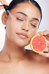 Image showing Woman, face and oil with beauty and grapefruit, skincare serum with natural cosmetics isolated on white background. Fruit, female model with pipette and vitamin c for skin with dermatology in studio