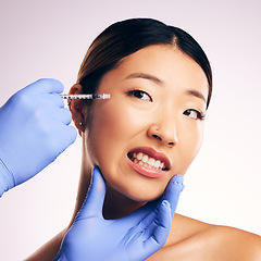 Image showing Face injection, skincare and Asian woman in pain in studio isolated on a white background. Cosmetics, syringe and female model with collagen filler, dermatology and prp facelift in plastic surgery.