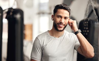 Image showing Fitness, gym and a man with earphones for music for wellness, health and training with a smile. Face portrait of a person listening to audio, radio or podcast for exercise or workout at wellness club