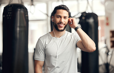 Image showing Fitness, portrait of man with earphones and in gym happy for health wellness. Exercise or training, sportswear and smiling male athlete listening to music or podcast for motivation for workout.