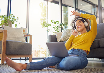 Image showing Headphones, computer and home of woman dancing, singing and happy music, podcast streaming or audio. Floor, carpet and young african person on laptop, electronics and web listening in her living room