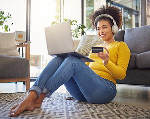 Image showing Headphones, credit card and woman on laptop for home online shopping, ecommerce or fintech payment on floor. Relax, music and happy african person on internet banking, audio subscription and computer