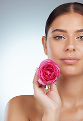 Image showing Face, skincare and woman with rose flower in studio isolated on a white background. Portrait, natural plant and serious female model with pink floral for makeup cosmetics, beauty treatment and mockup