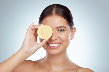 Image showing Face, skincare and happy woman with lemon in studio isolated on a white background. Portrait, natural and female model with fruit for vitamin c, vegan nutrition or healthy diet, wellness or cosmetics