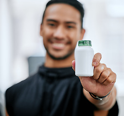 Image showing Fitness drugs, hand and a man at the gym with a supplement for training and sport. Happy, portrait and an Asian athlete showing a bottle of medicine or vitamins for sports wellness and exercise