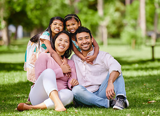 Image showing Hug, portrait and asian family at a park smile, happy and having fun outdoor together. Face, love and children with parents on forest ground, sitting and embrace while enjoying nature on the weekend