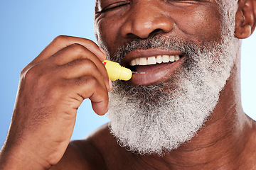 Image showing Skincare, lip balm and black man with cosmetics, smile and dermatology against a blue studio background. Male person, mature guy and happy model with grooming for the mouth, lip gloss and treatment