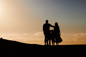 Image showing Parents, kids and silhouette on mountain, sunset and hug with love, care and summer adventure. Mother, father and young children with sky background, space and outdoor on holiday, vacation or journey