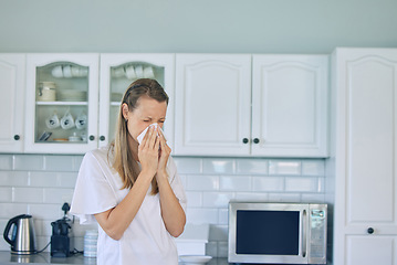 Image showing Allergies, toilet paper and woman blowing her nose in the kitchen for a cold, flu or sneeze at her home. Illness, virus and young female person with tissue for sinus, hay fever or covid in apartment.