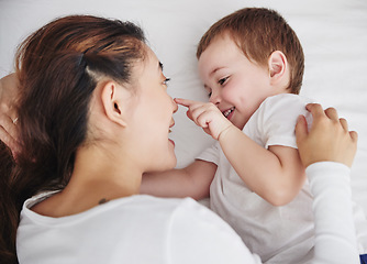 Image showing Love, mother and baby in bed from above, happy and playing, bonding and talking in their home. Family, relax and top view of mom with toddler in a bedroom, wake up and smile while enjoying resting