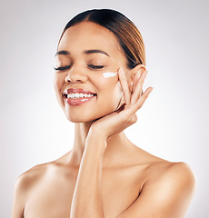 Image showing Woman, cream on face and beauty with skincare, smile and moisturizer isolated on studio background. Happy female model apply lotion, dermatology and cosmetic product with skin glow and facial