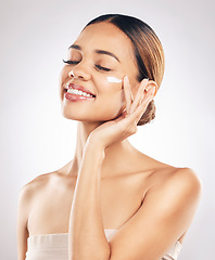 Image showing Woman with smile, cream on face and beauty, skincare and moisturizer isolated on studio background. Happy female model apply lotion, dermatology and cosmetic product with skin glow and facial