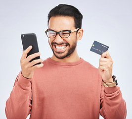 Image showing Man is excited, smartphone and credit card, online shopping bonus with discount or promo on studio background. Positive customer experience, ecommerce and fintech, happy male person with sale and win