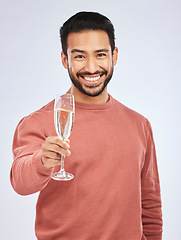 Image showing Man with smile in portrait, champagne and cheers with celebration and happiness isolated on studio background. Toast with alcohol drink in glass, happy male model and party, celebrate with drinking