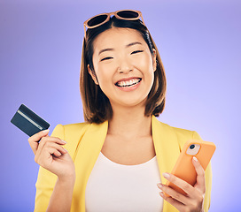 Image showing Cellphone, card and portrait of a woman in studio for online shopping on ecommerce website. Happy, smile and Asian female model with internet banking for paying bills with phone by purple background.