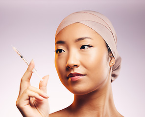 Image showing Woman, face and plastic surgery with injection and studio background with asian for skincare. Female model, cosmetic and syringe for beauty, wellness and collagen for skin and closeup with filler.