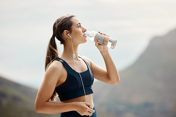 Image showing Fitness, woman with earphones, drinking water and hiking in nature for health and wellness during exercise. Music, bottle and fit girl on hike in park for body workout with radio streaming or podcast