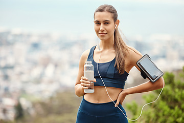 Image showing Portrait of woman with earphones, drink water and hiking with fitness app in nature for health and wellness. Music, bottle and girl on mountain with phone for workout with radio streaming or podcast.