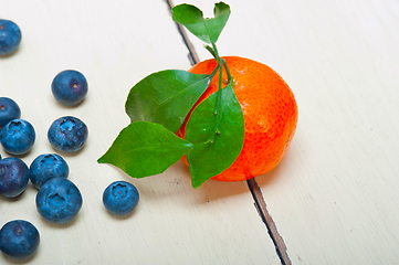 Image showing tangerine and blueberry on white table