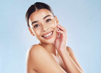 Image showing Portrait, beauty and woman with cosmetics, luxury and salon treatment against a blue studio background. Face, female person and model with dermatology, skincare and wellness with aesthetic and smile