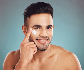 Image showing Portrait, skincare and cream with a man in studio on a gray background to apply antiaging facial treatment. Face, beauty and lotion with a young male person indoor for wellness or aesthetic self care