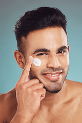 Image showing Portrait, skincare and lotion with a man in studio on a gray background to apply antiaging facial treatment. Face, beauty and cream with a young male person indoor for wellness or aesthetic self care