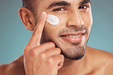 Image showing Portrait, facial and cream with a man in studio on a gray background to apply antiaging skincare treatment. Face, beauty or lotion with a young male person applying spf sunscreen indoor for self care