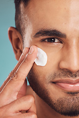 Image showing Portrait, facial and lotion with a man in studio on a gray background to apply antiaging skincare treatment. Face, beauty or cream with a young male person applying spf sunscreen indoor for self care