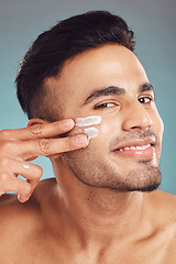 Image showing Portrait, skin care and cream with a man in studio on a gray background to apply antiaging face treatment. Facial, beauty or lotion with a young male person indoor for wellness or aesthetic self care