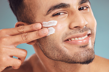 Image showing Portrait, beauty and skin cream with a man in studio on a gray background to apply antiaging facial treatment. Face, skincare and lotion with a young person indoor for wellness or aesthetic self care