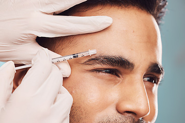 Image showing Beauty, botox and eyebrow with a man in studio on a gray background for a plastic surgery injection. Hands, skincare and syringe with a young male person indoor for an antiaging facial filler closeup