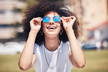 Image showing Woman, fashion and sunglasses outdoor in city for happiness, summer and travel holiday. Face of african person with natural hair or afro at nature park with glasses and positive mindset for freedom