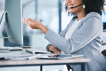 Image showing Call center, customer service and a woman talking at computer with microphone. Hand and smile of african person as crm, telemarketing and sales or technical support agent with headset and desktop pc