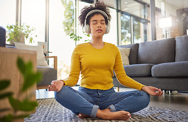 Image showing Meditation, headphones and woman in home wellness, mental health or yoga podcast in living room. Music, streaming and african person meditate, holistic exercise and peace or lotus on audio technology