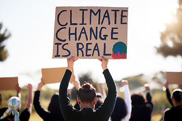 Image showing Protest, global warming and sign with a group of people outdoor at a rally or march for conservation. Climate change, poster and environment with a crowd walking together during a community strike