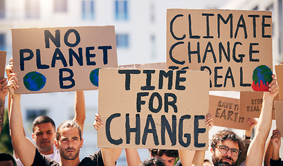 Image showing Group, poster and together in street for planet, climate change and sustainable future in city. People, cardboard sign and activism for change, sustainability or justice for environment in metro road