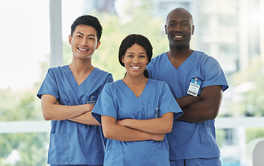 Image showing Confidence, crossed arms and portrait of team of doctors standing in the hallway of hospital. Happy, diversity and group of professional medical workers with smile in collaboration at medicare clinic